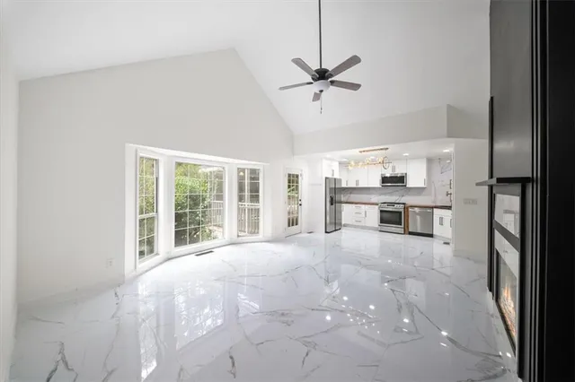 a view of an empty room with a window and wooden floor