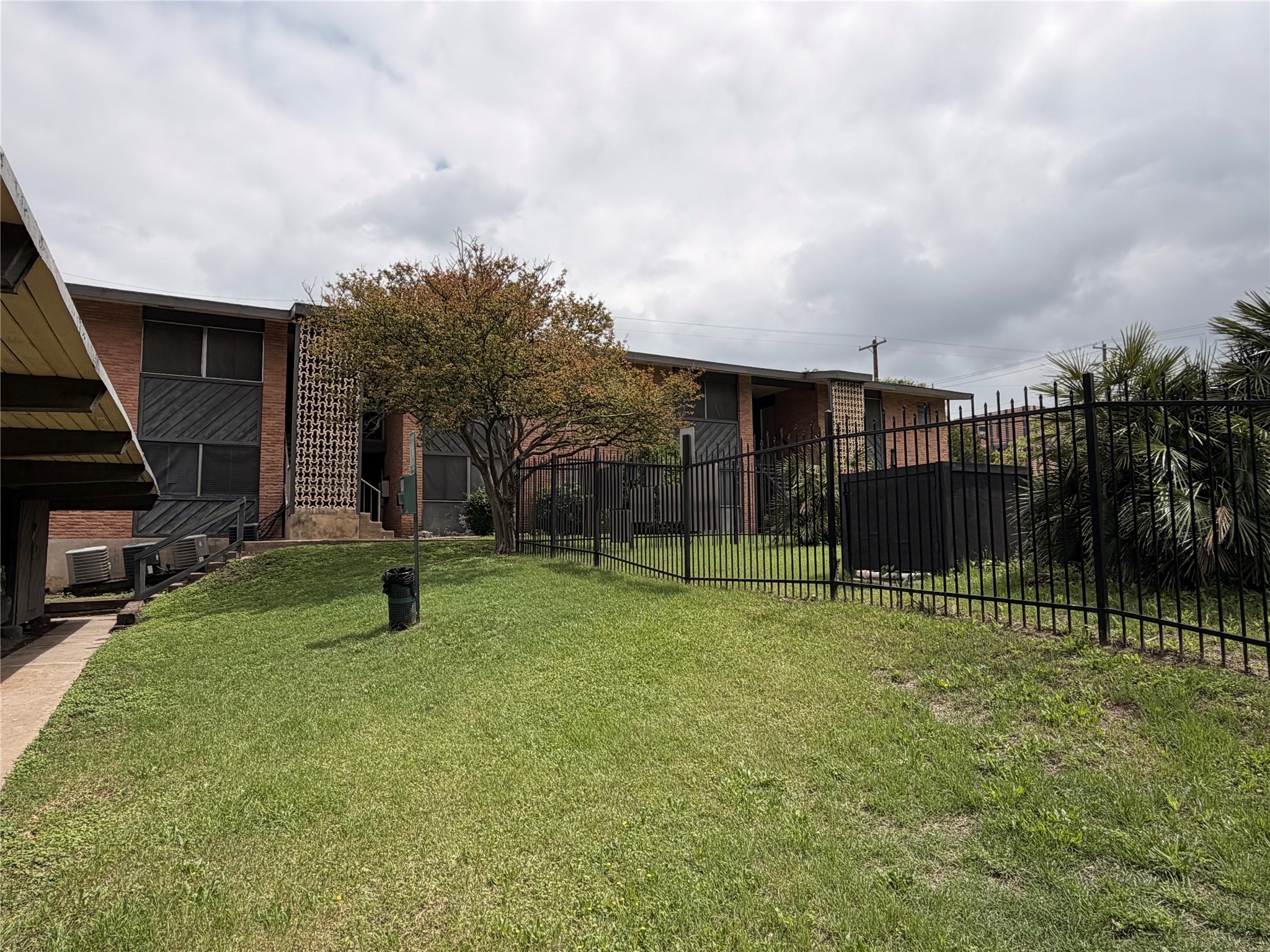3304 Red River Street, Unit 203 Austin, TX 78705 - Photo 1 of 16 a backyard of a house with a slide and swing