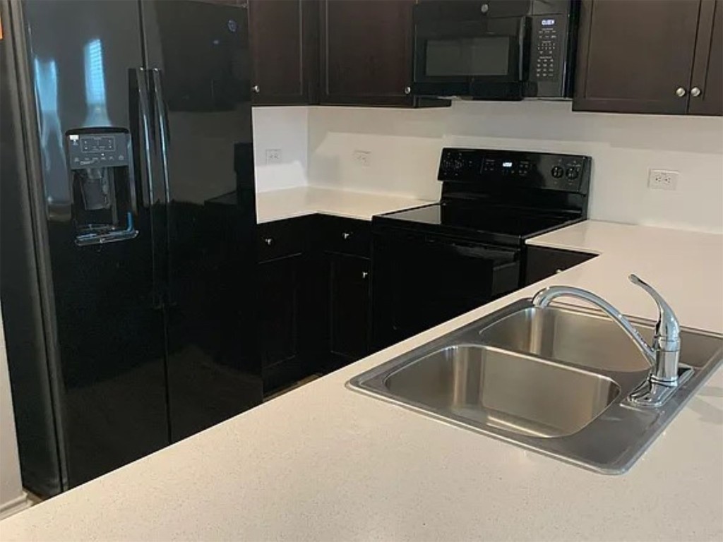 136 Texas Angel Way Jarrell, TX 76537 - Photo 3 of 12 a kitchen with a sink and a refrigerator