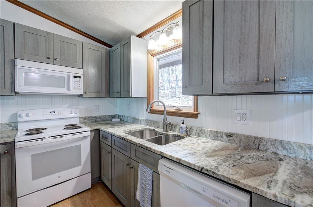 147 Laurel Mill Trail Jasper, GA 30143 - Photo 15 of 64 a kitchen with granite countertop a sink stove and microwave