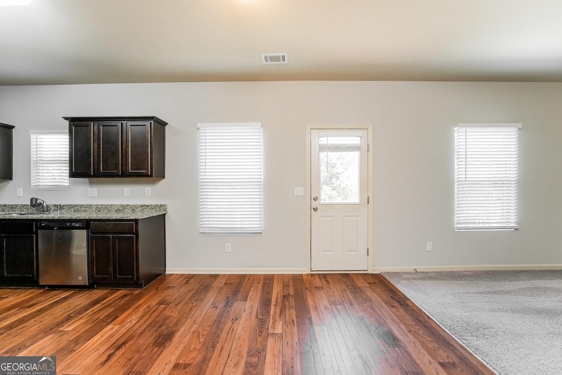 830 Castilla Way Winder, GA 30680 - Photo 4 of 23 an empty room with kitchen appliances and wooden floor