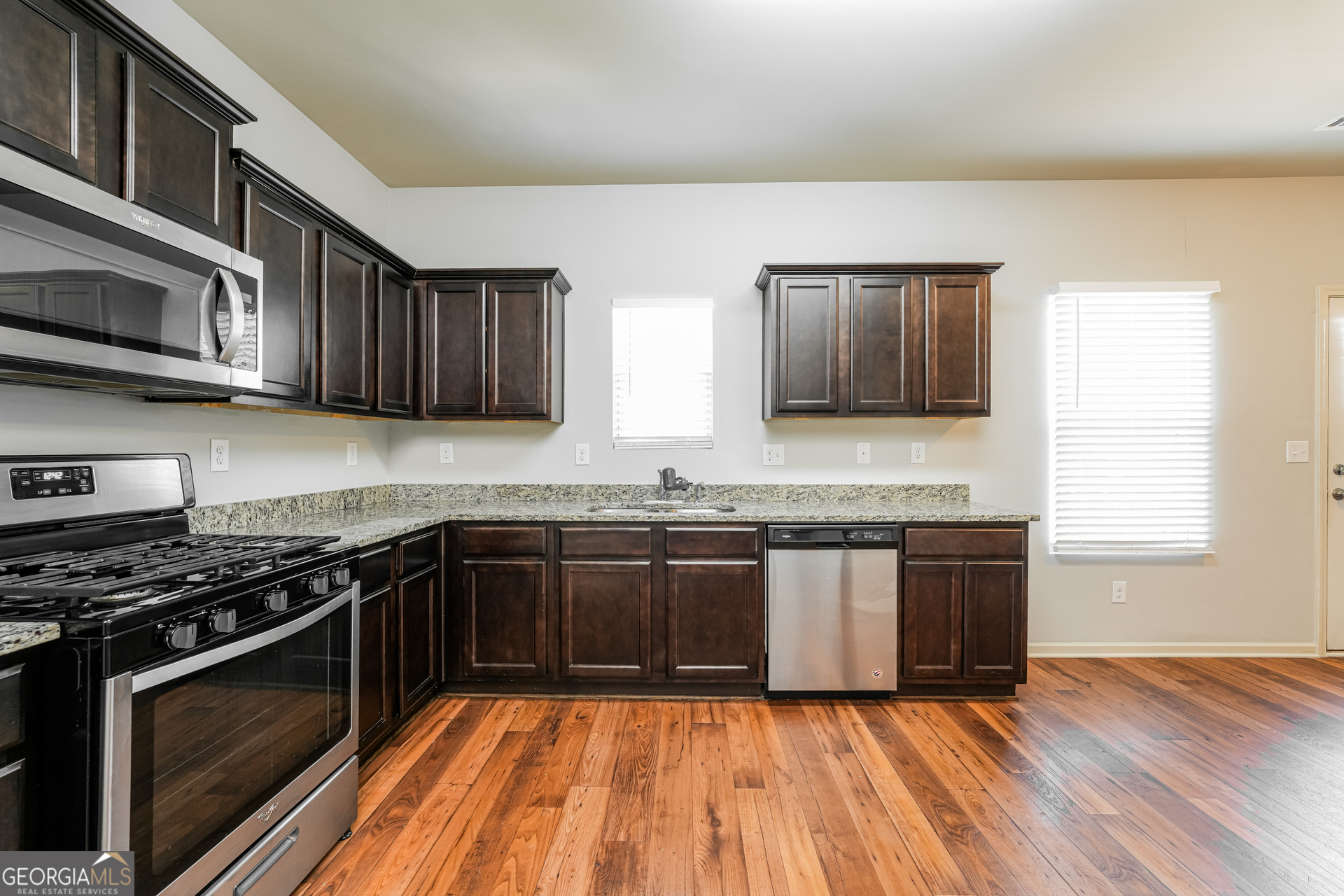 830 Castilla Way Winder, GA 30680 - Photo 5 of 23 a kitchen with stainless steel appliances granite countertop wooden cabinets stove top oven and sink