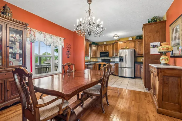 a view of a dining room with furniture a chandelier and wooden floor