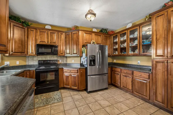 a kitchen with stainless steel appliances granite countertop a refrigerator stove and sink