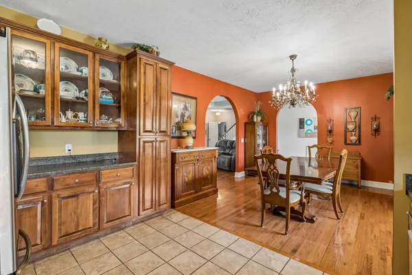 a very nice looking dining room with kitchen island granite countertop furniture a fireplace and a chandelier