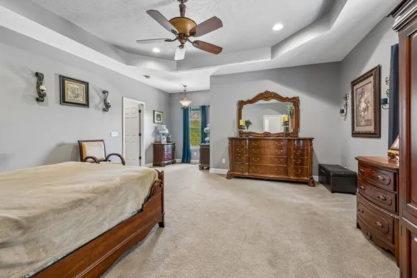 a spacious bedroom with a bed and a dresser
