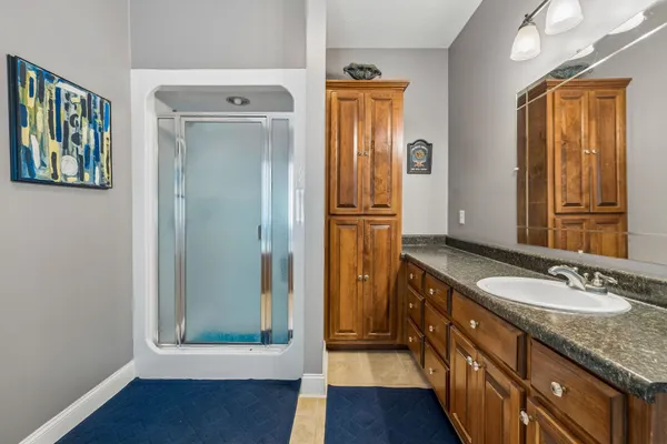 a bathroom with a granite countertop sink and a mirror