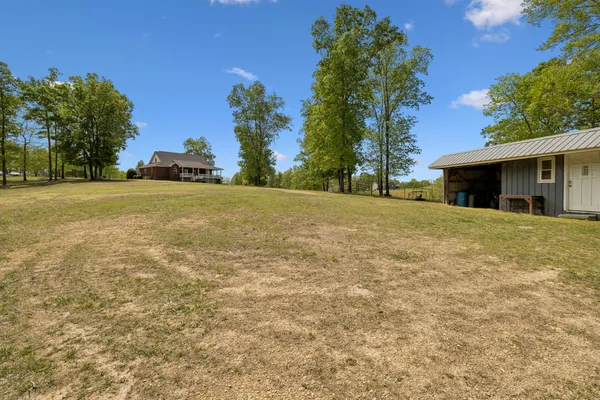 a front view of a house with a yard and trees