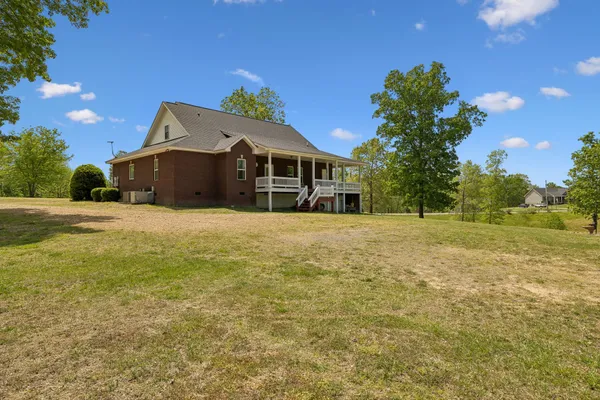 a front view of house with yard and trees in the background