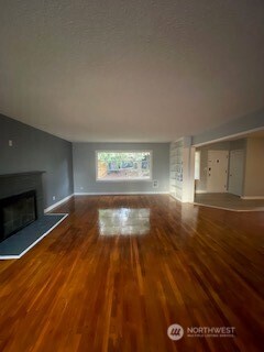 6221 South 129th Street Seattle, WA 98178 - Photo 3 of 20 a view of empty room with wooden floor and fireplace