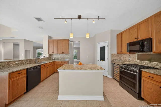 a view of a kitchen counter top space a sink stainless steel appliances and cabinets