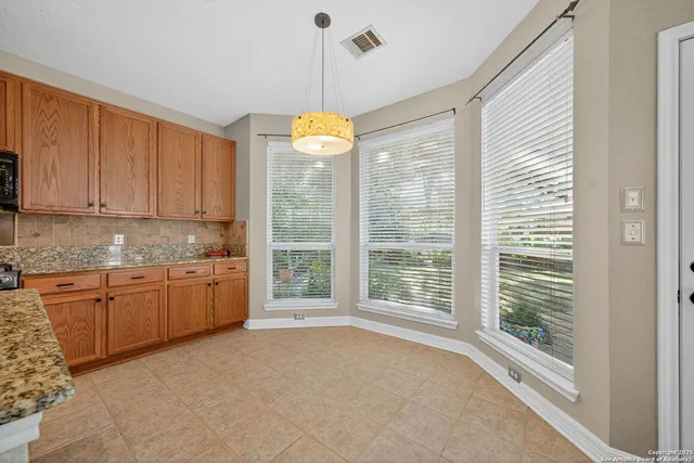 a open kitchen with granite countertop sink and white cabinets
