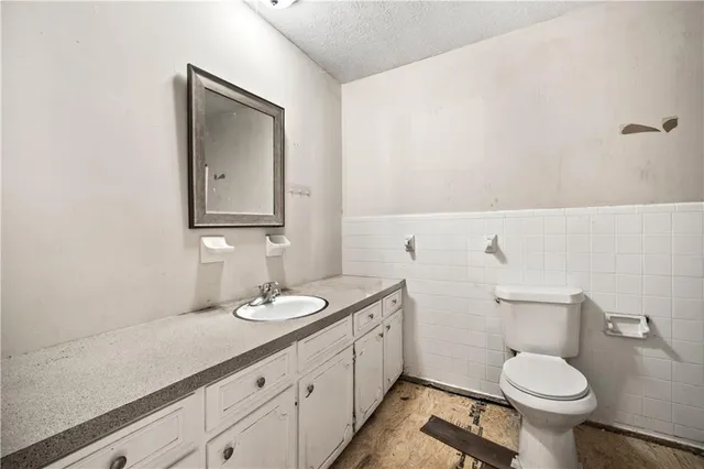 a bathroom with a granite countertop toilet sink and mirror