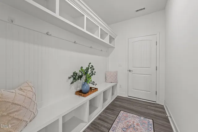 a hallway with white cabinets and wooden floor