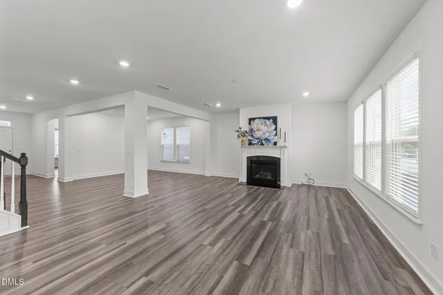 a view of empty room with wooden floor and fireplace