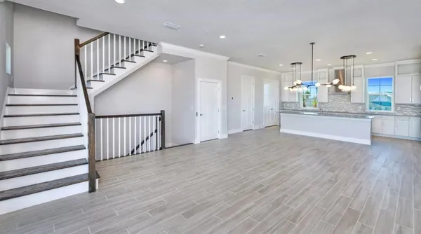 a view of a kitchen with wooden floor and staircase