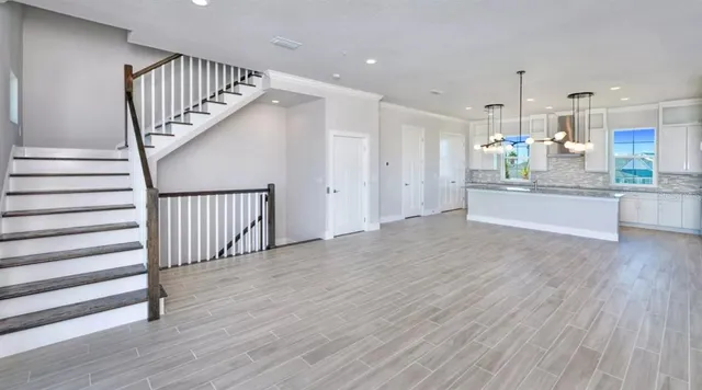 a view of a kitchen with wooden floor and staircase