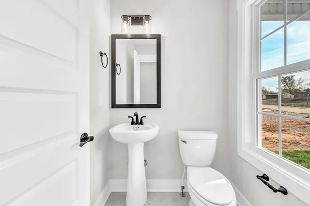 a bathroom with a toilet sink and mirror