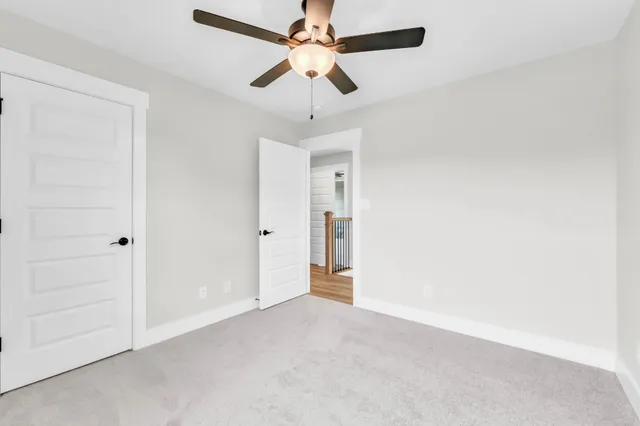 an empty room with a ceiling fan and a window
