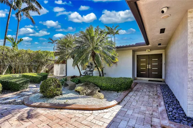 a living room with stainless steel appliances granite countertop a couch and a fireplace with the wooden floor