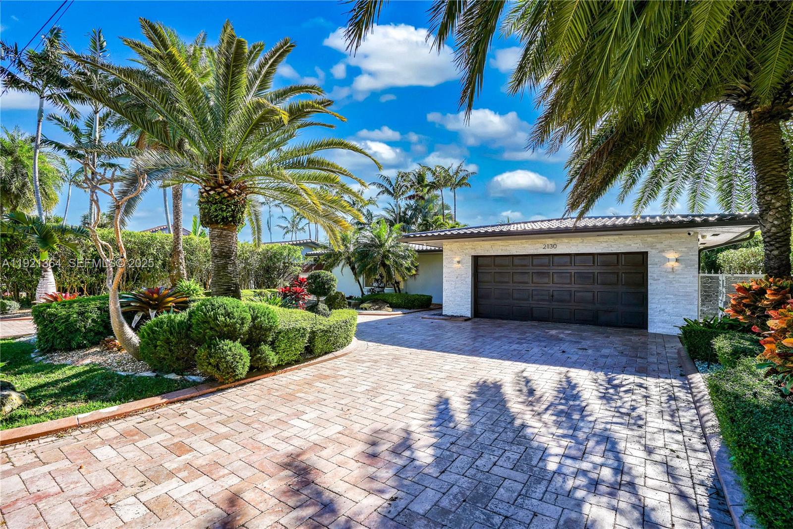 2130 Northeast 122nd Road North Miami, FL 33181 - Photo 41 of 86 a front view of a house with a yard and a garage