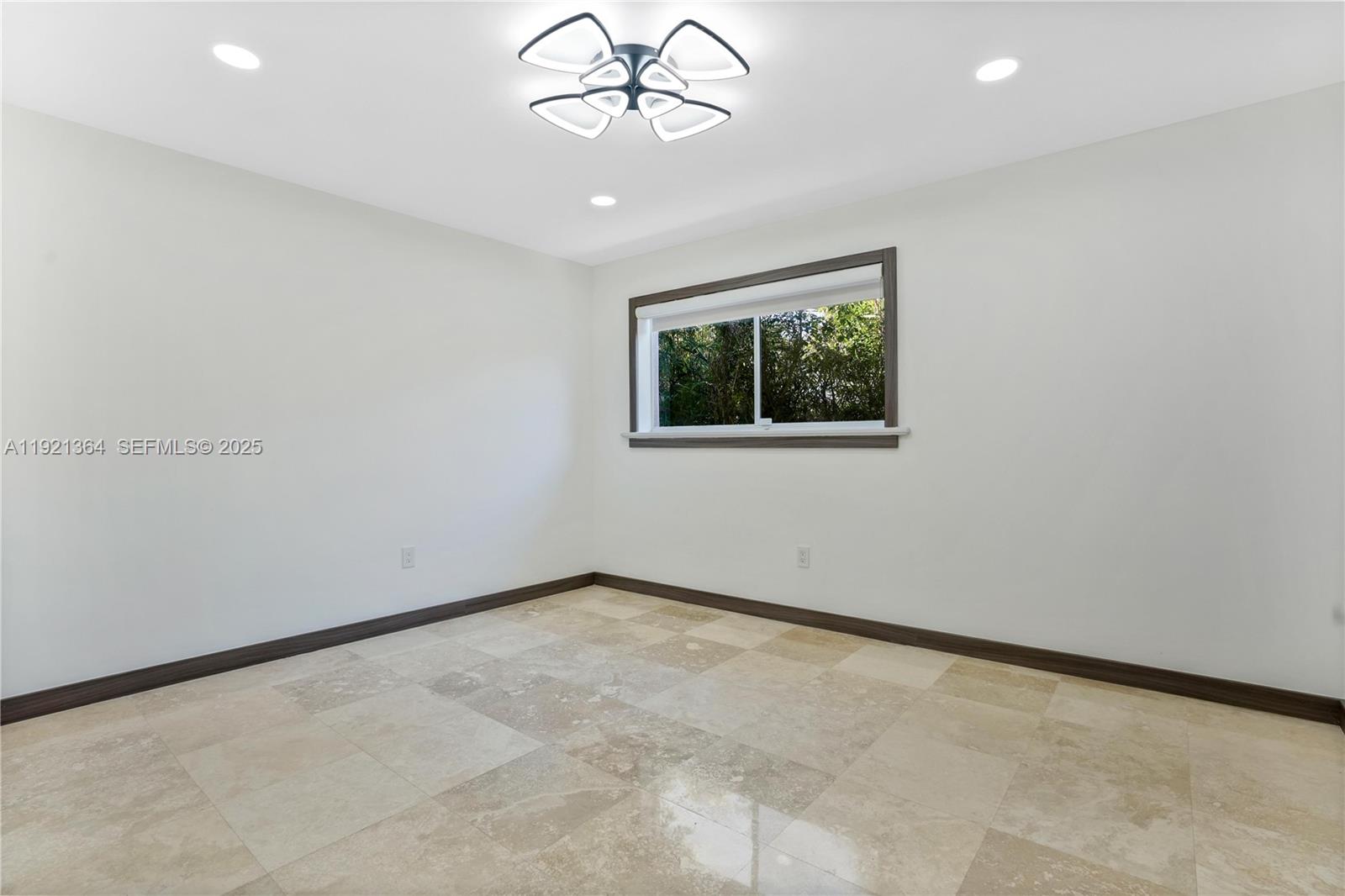 2130 Northeast 122nd Road North Miami, FL 33181 - Photo 59 of 86 an empty room with a chandelier fan and windows