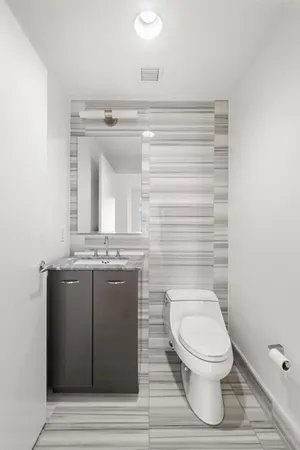 a bathroom with a granite countertop toilet a sink and mirror