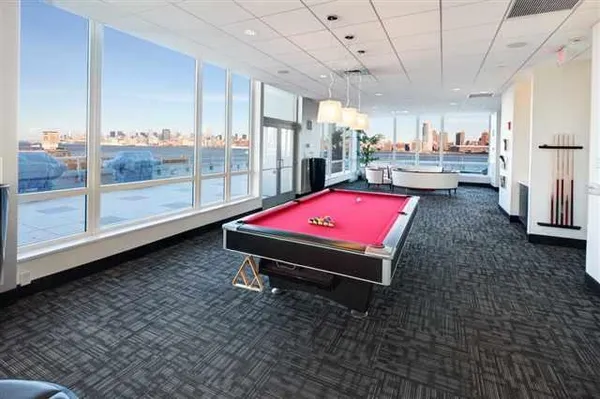 a room with pool table and wooden floor