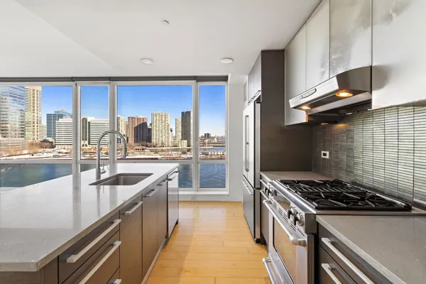 a kitchen with stainless steel appliances granite countertop a sink stove and refrigerator