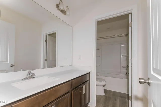 a bathroom with a sink a toilet and a mirror