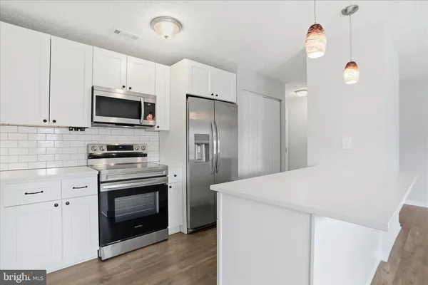a kitchen with stainless steel appliances a stove microwave and a refrigerator