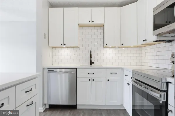 a kitchen with white cabinets and white appliances