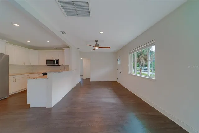 a view of a kitchen with wooden floor and a ceiling fan