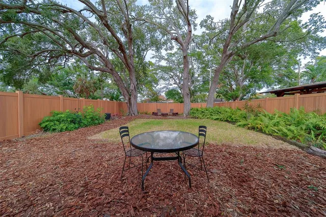a backyard of a house with table and chairs