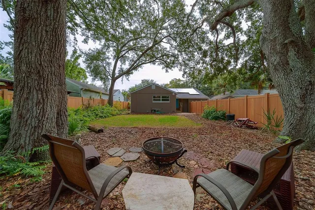 a backyard of a house with barbeque oven and seating space