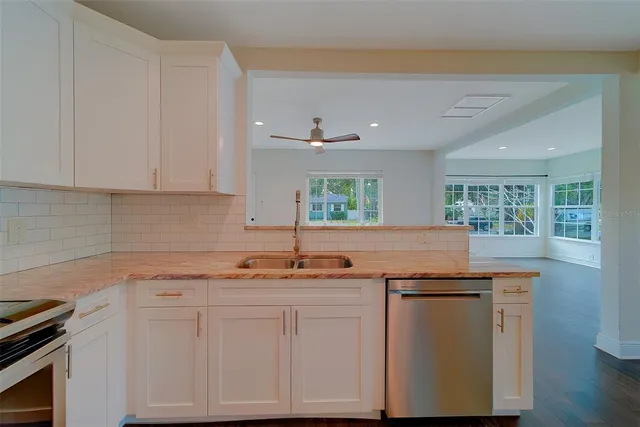 a kitchen with stainless steel appliances granite countertop a refrigerator a sink and a stove