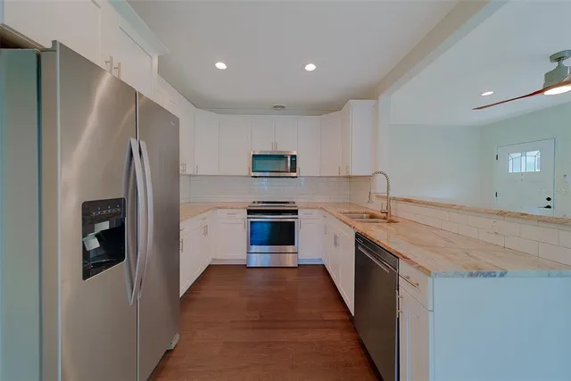a kitchen with cabinets stainless steel appliances and a sink