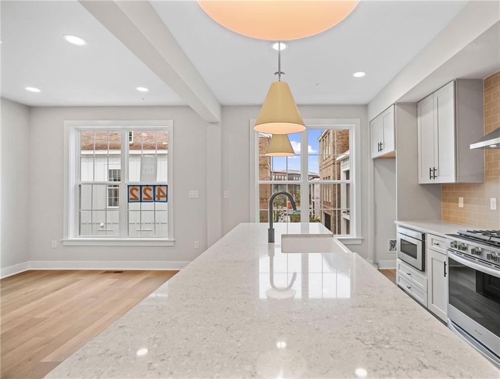 212 Oliver Way Cranberry Township, PA 16066 - Photo 8 of 49 a view of a kitchen with kitchen island a sink a stove and wooden floor