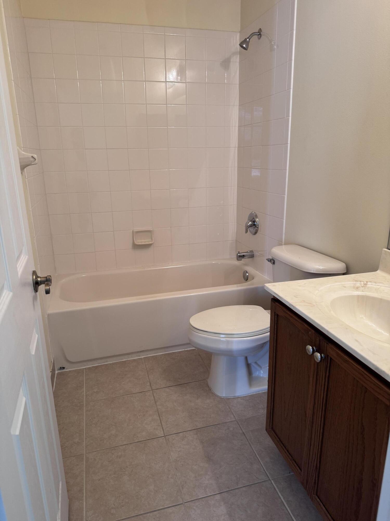 2755 Southeast Birmingham Drive, Unit 3 Stuart, FL 34994 - Photo 20 of 23 a bathroom with a granite countertop toilet sink and shower