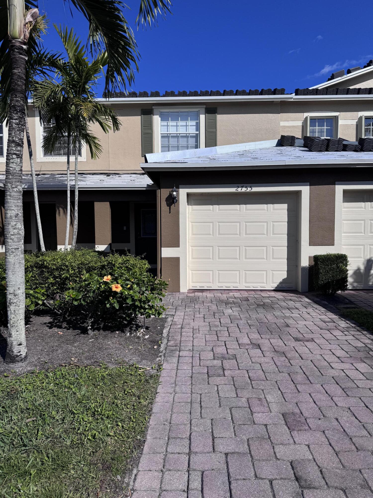2755 Southeast Birmingham Drive, Unit 3 Stuart, FL 34994 - Photo 2 of 23 a front view of a house with a yard and garage
