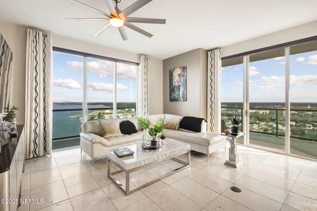 a living room with furniture and large windows