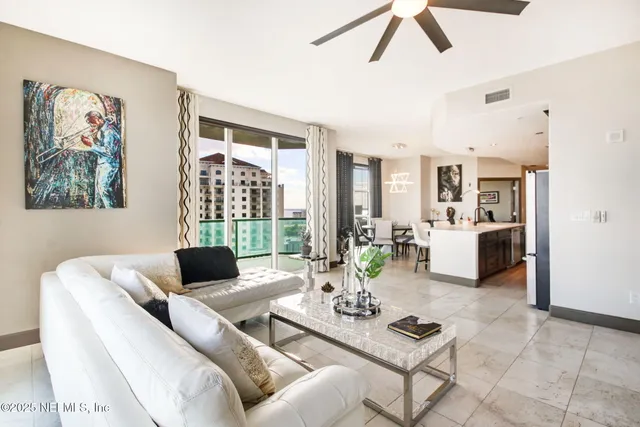 a living room with furniture and floor to ceiling windows