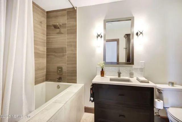 a bathroom with a tub sink and mirror