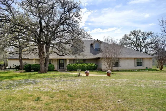 a view of a house with a yard and sitting area
