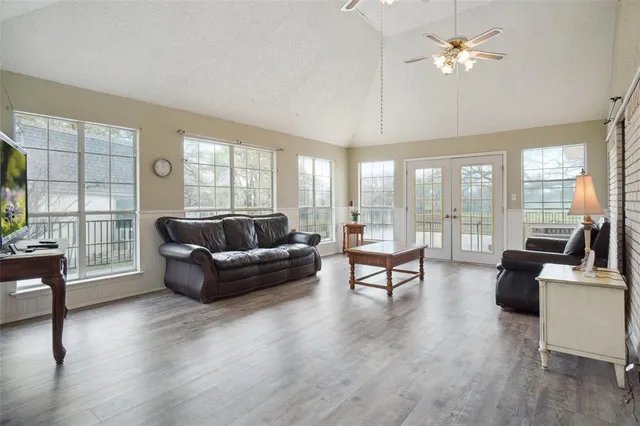 a living room with furniture and a large window with wooden floor