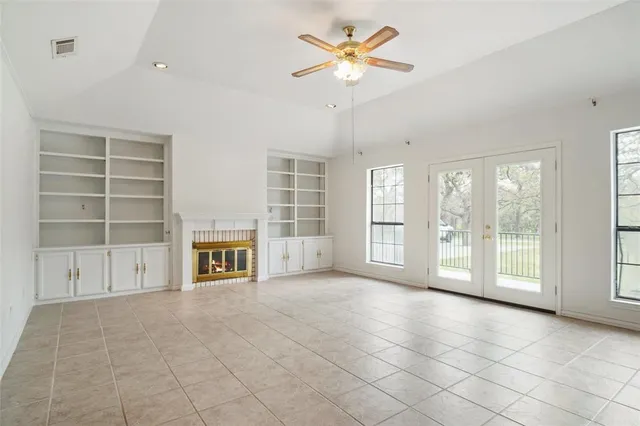 a view of an empty room with a fireplace and a window