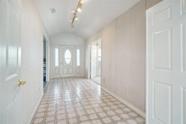 a view of a hallway with wooden floor and a chandelier