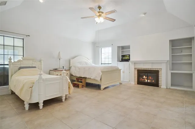 a spacious bedroom with a bed and a fireplace