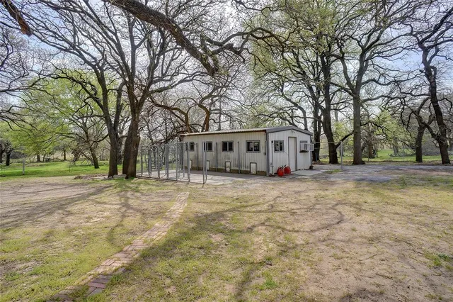 a front view of a house with a garden and trees
