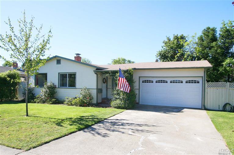 a front view of house with yard and trees around